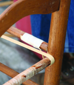 closeup of the end of a reed taped to the chair before the rest of…